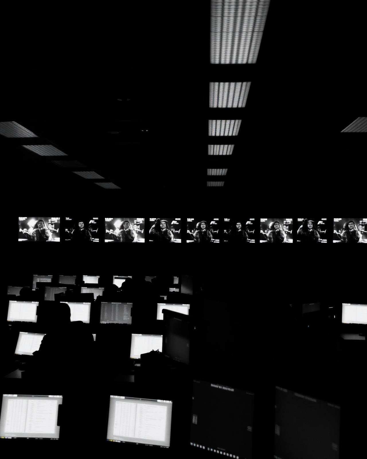 A darkened operations centre lit by rows of live monitors: state that updates now, not on a schedule
