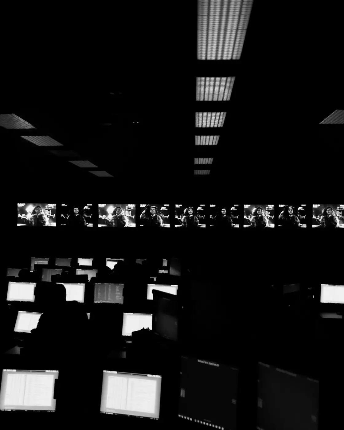 A darkened operations centre lit by rows of live monitors: state that updates now, not on a schedule